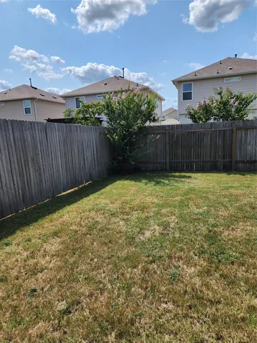 a view of a backyard with wooden fence
