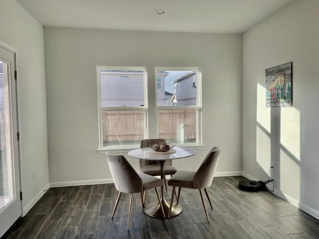 a dining room with furniture and wooden floor