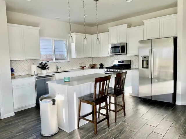 a kitchen with a sink a microwave a refrigerator and cabinets