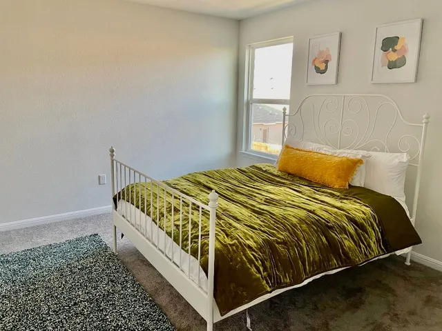 a bedroom with a bed and painting on the wall