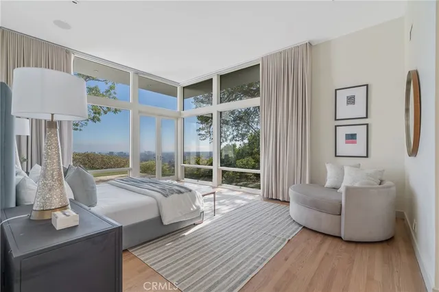 a living room with furniture large window and wooden floor