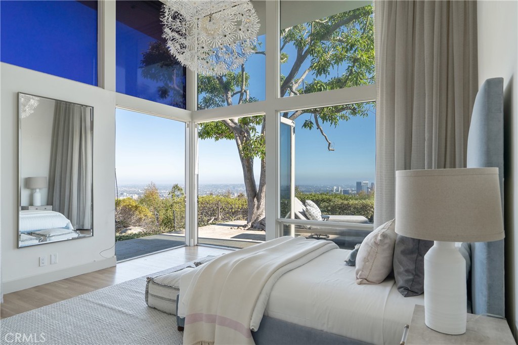 1436 Summitridge Drive Beverly Hills, CA 90210 - Photo 16 of 28 a bedroom with large window and a bed