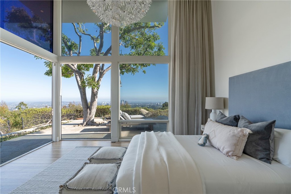 1436 Summitridge Drive Beverly Hills, CA 90210 - Photo 17 of 28 a bedroom with a bed and large window