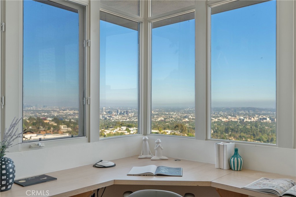 1436 Summitridge Drive Beverly Hills, CA 90210 - Photo 22 of 28 a room with window wooden floor and table