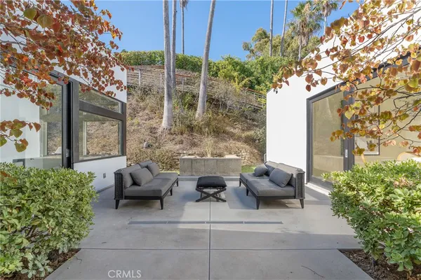 a view of a patio with couches table and chairs and potted plants