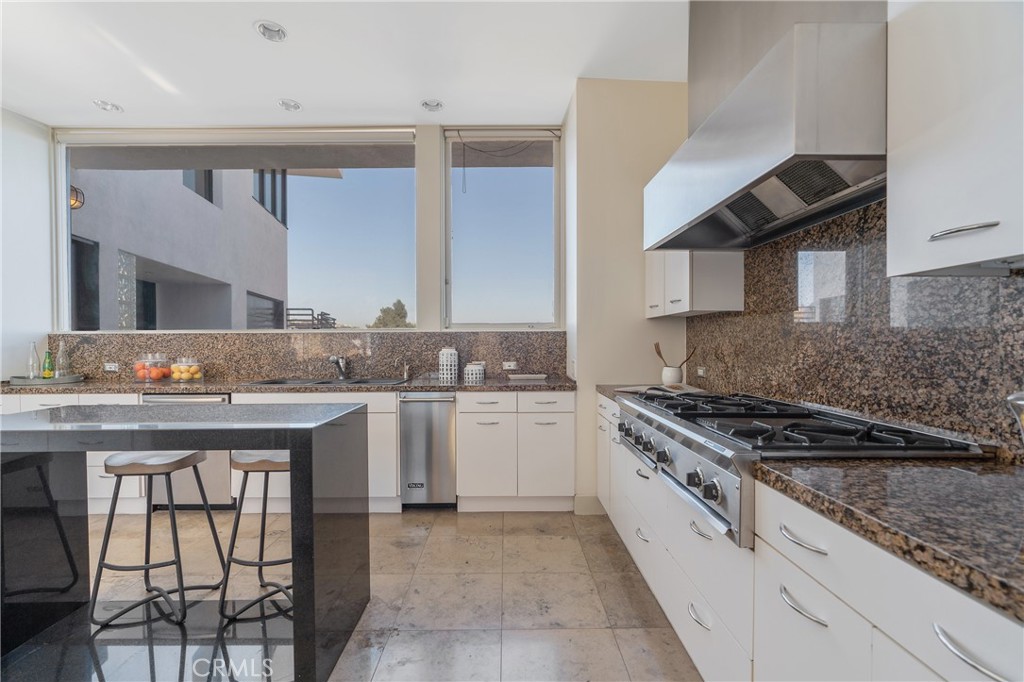 1436 Summitridge Drive Beverly Hills, CA 90210 - Photo 10 of 28 a kitchen with stainless steel appliances granite countertop a stove and cabinets