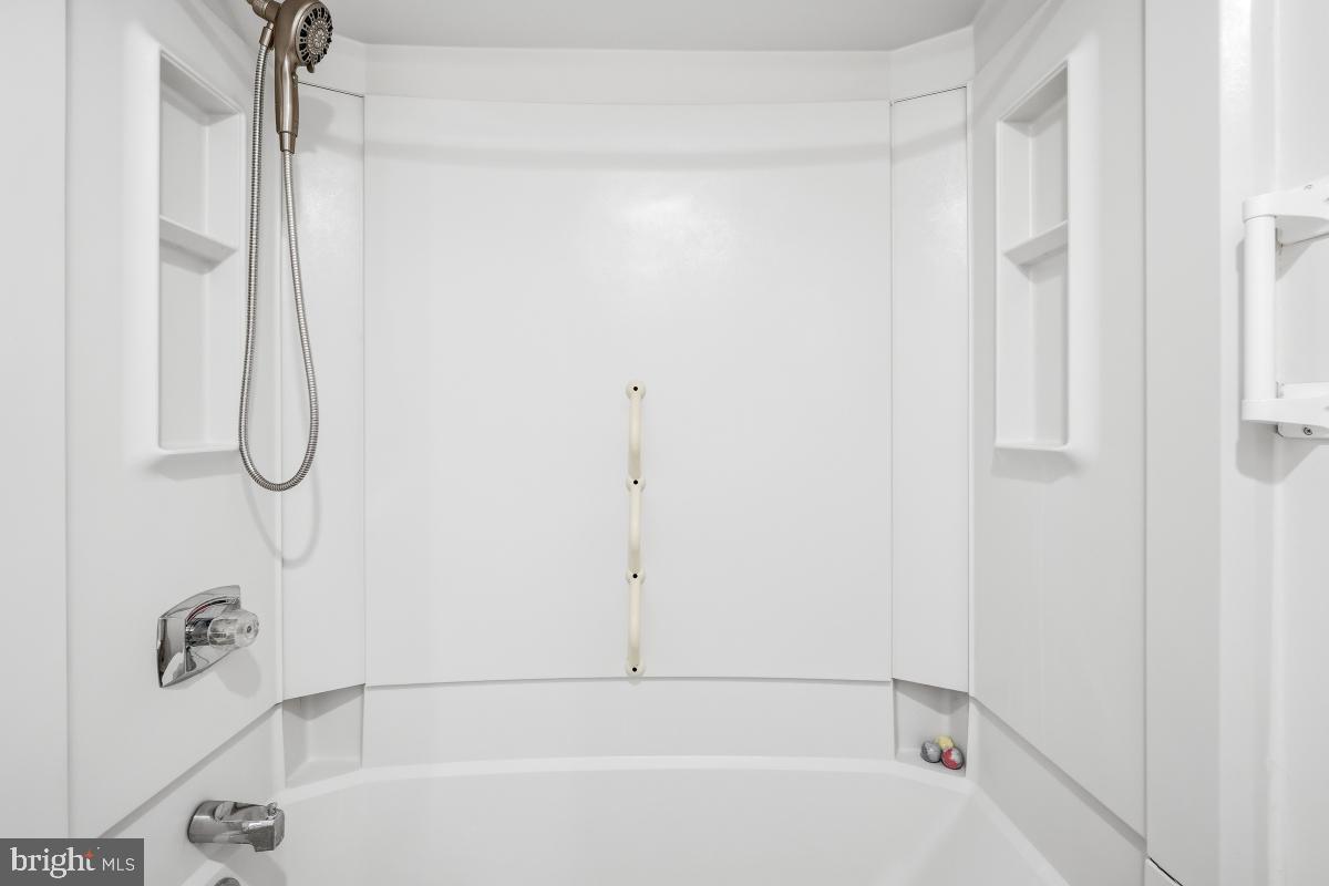 15107 Interlachen Drive, Unit 2215 Silver Spring, MD 20906 - Photo 13 of 31 a bathroom with a bath tub and a shower