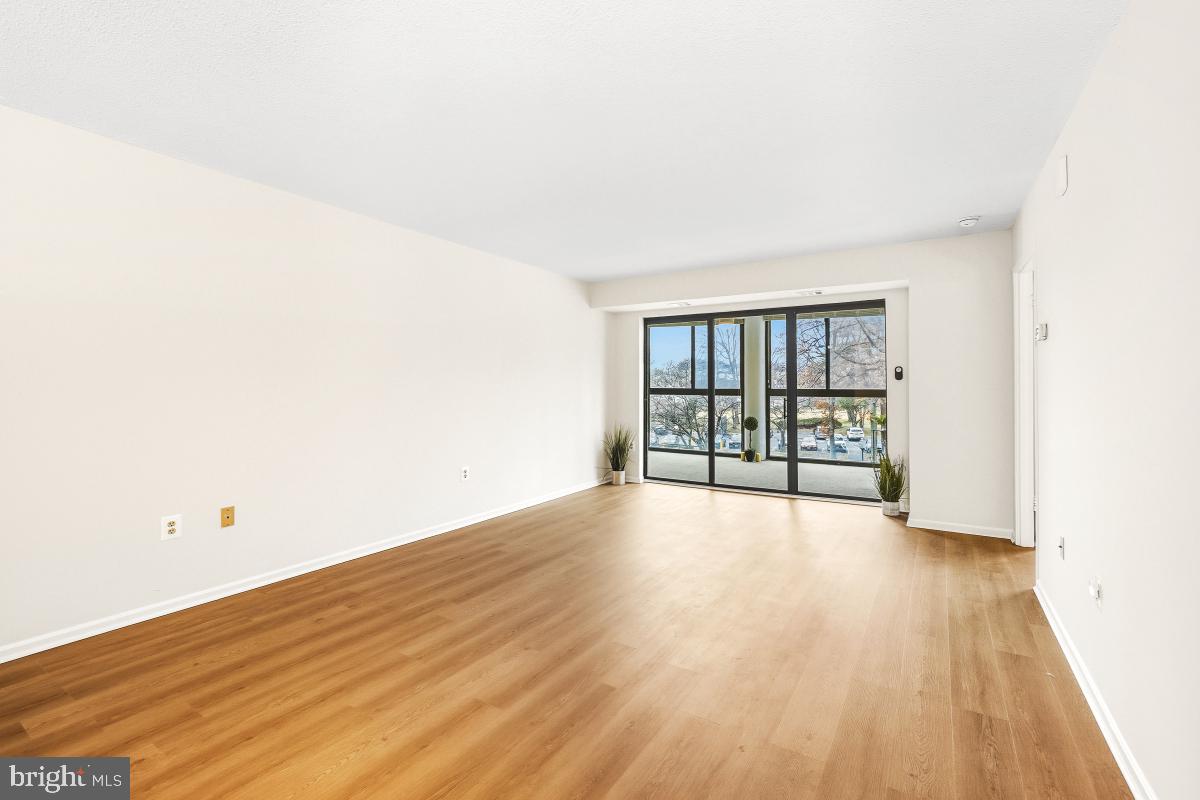 15107 Interlachen Drive, Unit 2215 Silver Spring, MD 20906 - Photo 19 of 31 an empty room with wooden floor and windows