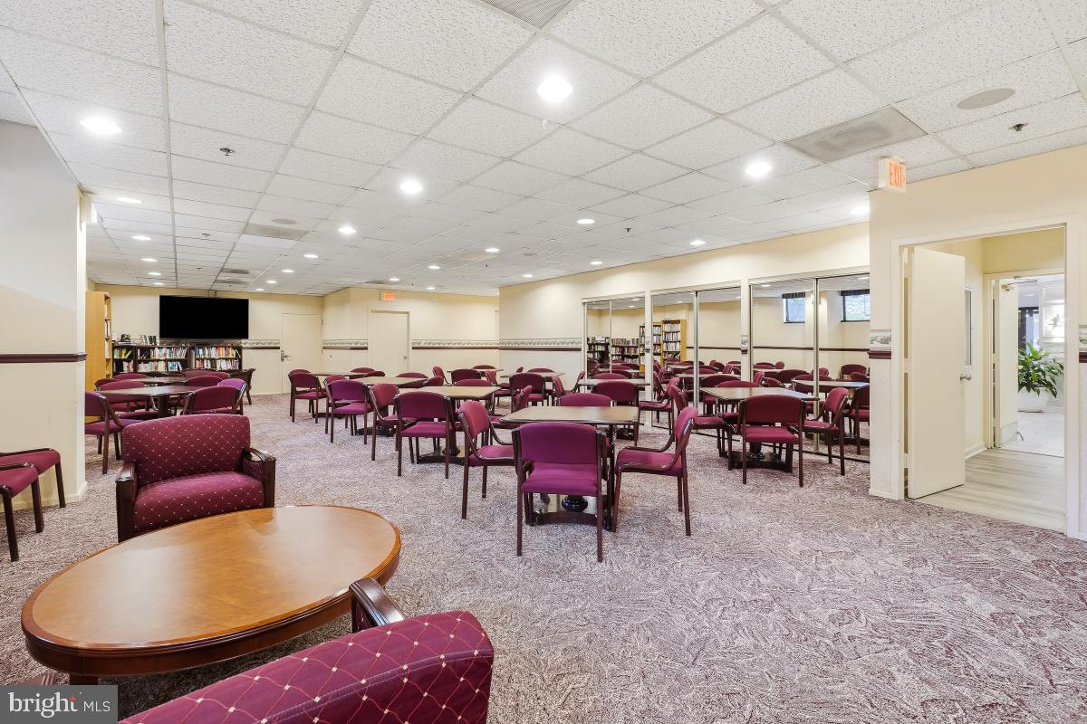 15107 Interlachen Drive, Unit 2215 Silver Spring, MD 20906 - Photo 23 of 31 a living room with lots of furniture a dining table and a fireplace