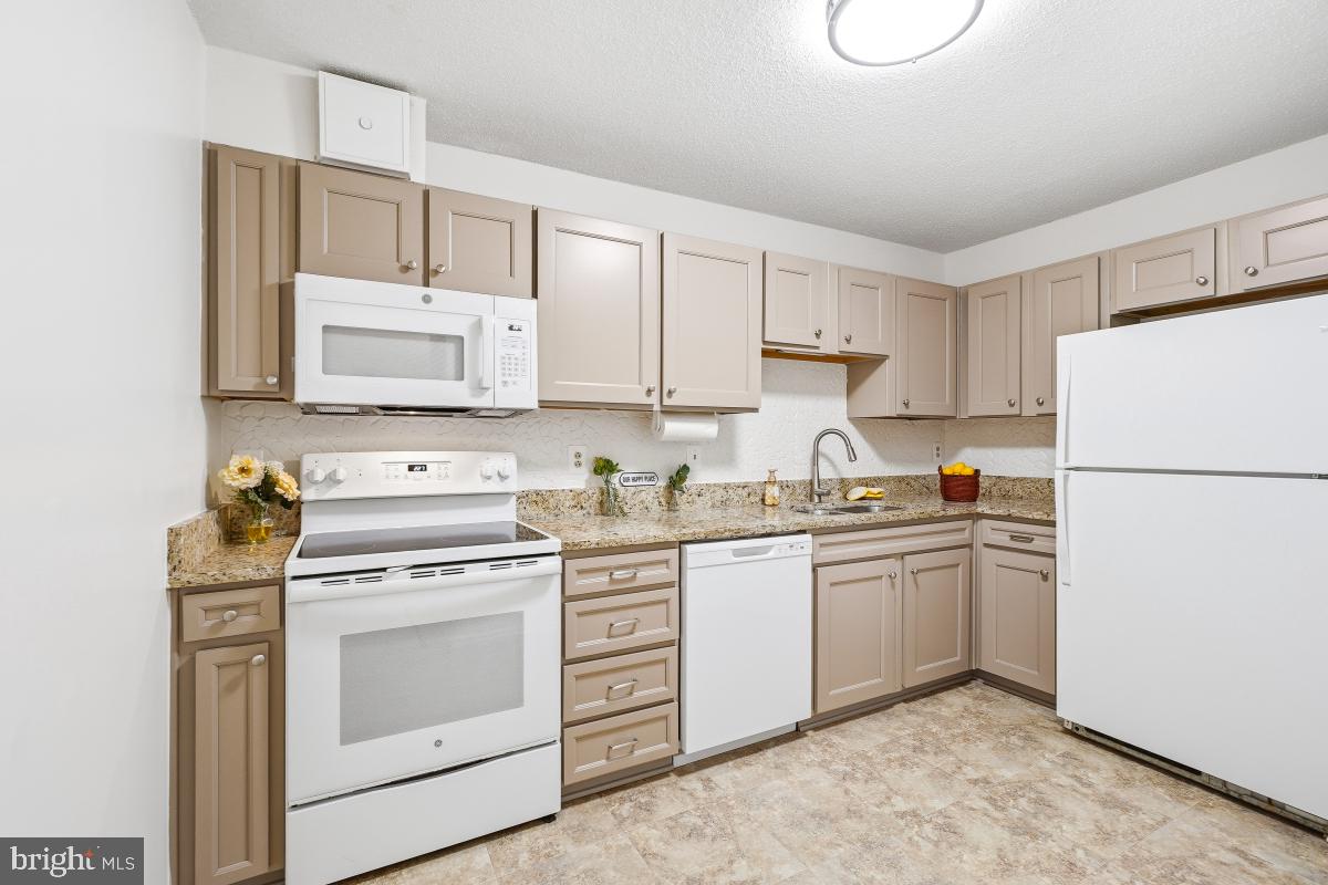 15107 Interlachen Drive, Unit 2215 Silver Spring, MD 20906 - Photo 3 of 31 a kitchen with appliances a sink and lots of white cabinets