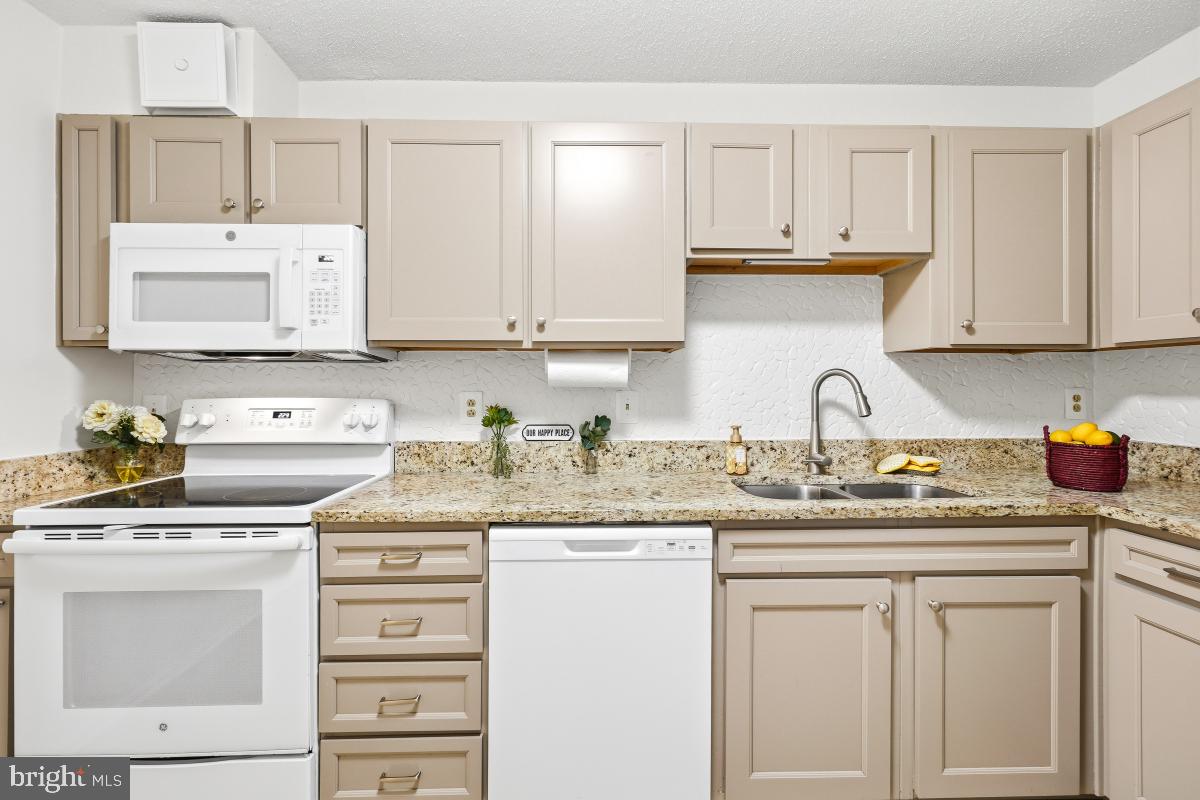 15107 Interlachen Drive, Unit 2215 Silver Spring, MD 20906 - Photo 4 of 31 a kitchen with granite countertop a sink stove and cabinets