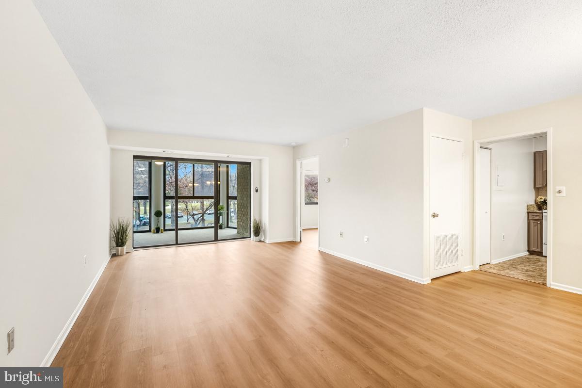 15107 Interlachen Drive, Unit 2215 Silver Spring, MD 20906 - Photo 5 of 31 a view of an empty room with wooden floor and a window