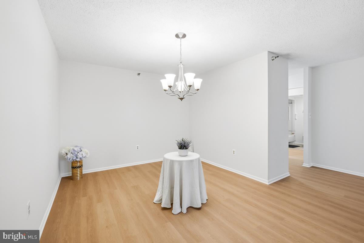 15107 Interlachen Drive, Unit 2215 Silver Spring, MD 20906 - Photo 6 of 31 a room with a chandelier fan and wooden floor