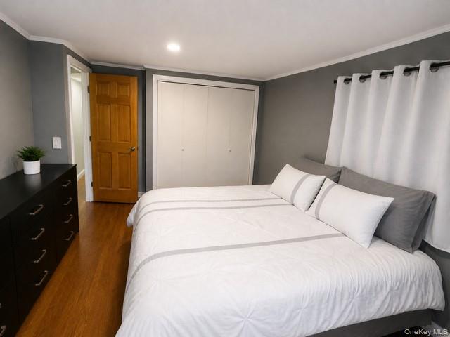 68 Whitford Road Westtown, NY 10998 - Photo 22 of 39 Bedroom featuring wood-finish flooring, a wood-paneled door, and white bi-fold closet doors