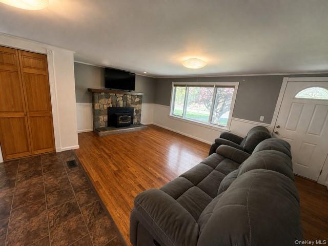 68 Whitford Road Westtown, NY 10998 - Photo 27 of 39 Living area featuring wood-finish flooring, a stone-faced fireplace with hearth, and wainscoting