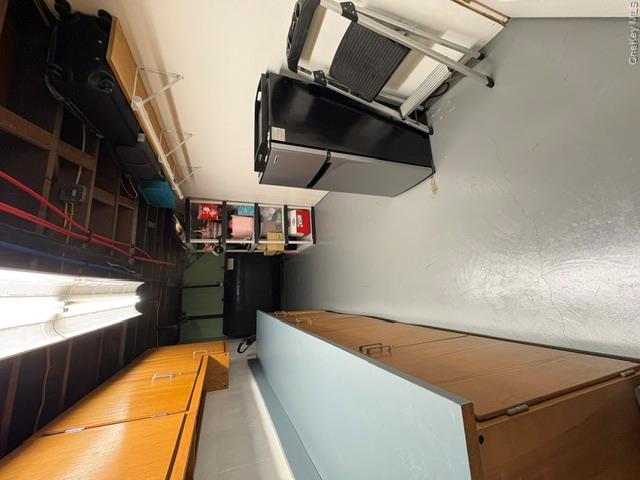 68 Whitford Road Westtown, NY 10998 - Photo 34 of 39 Utility space featuring extensive wood cabinetry with light blue countertops, exposed ceiling joists with visible piping, and light gray painted concrete flooring