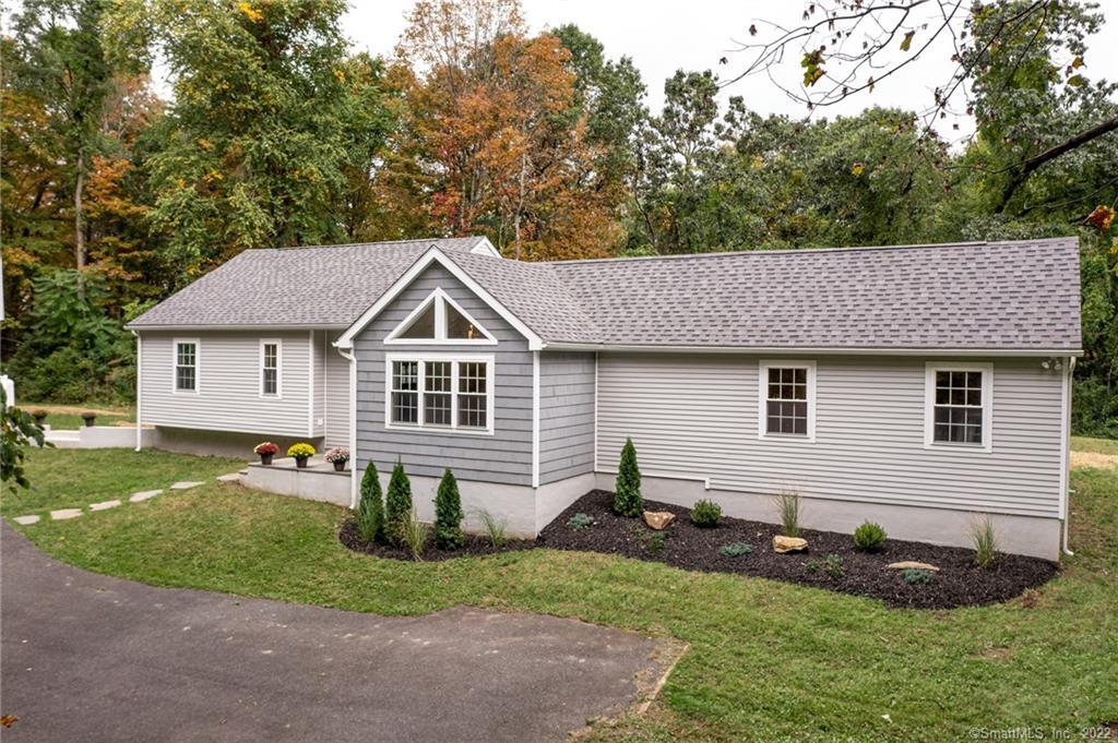 a front view of a house with a yard and trees