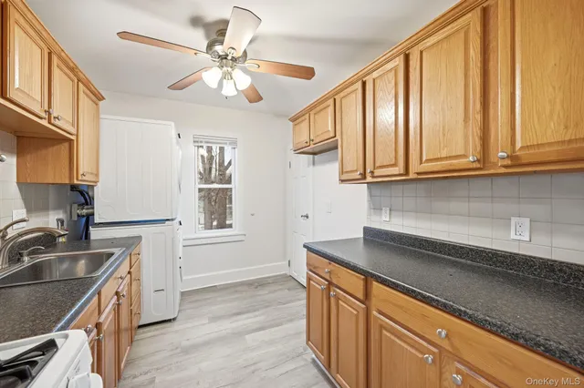 a kitchen with stainless steel appliances granite countertop a sink cabinets and wooden floor