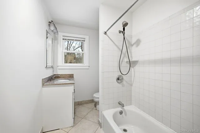 a bathroom with a granite countertop sink a toilet and shower