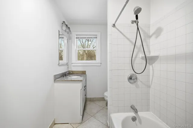 a bathroom with a sink a window and tub