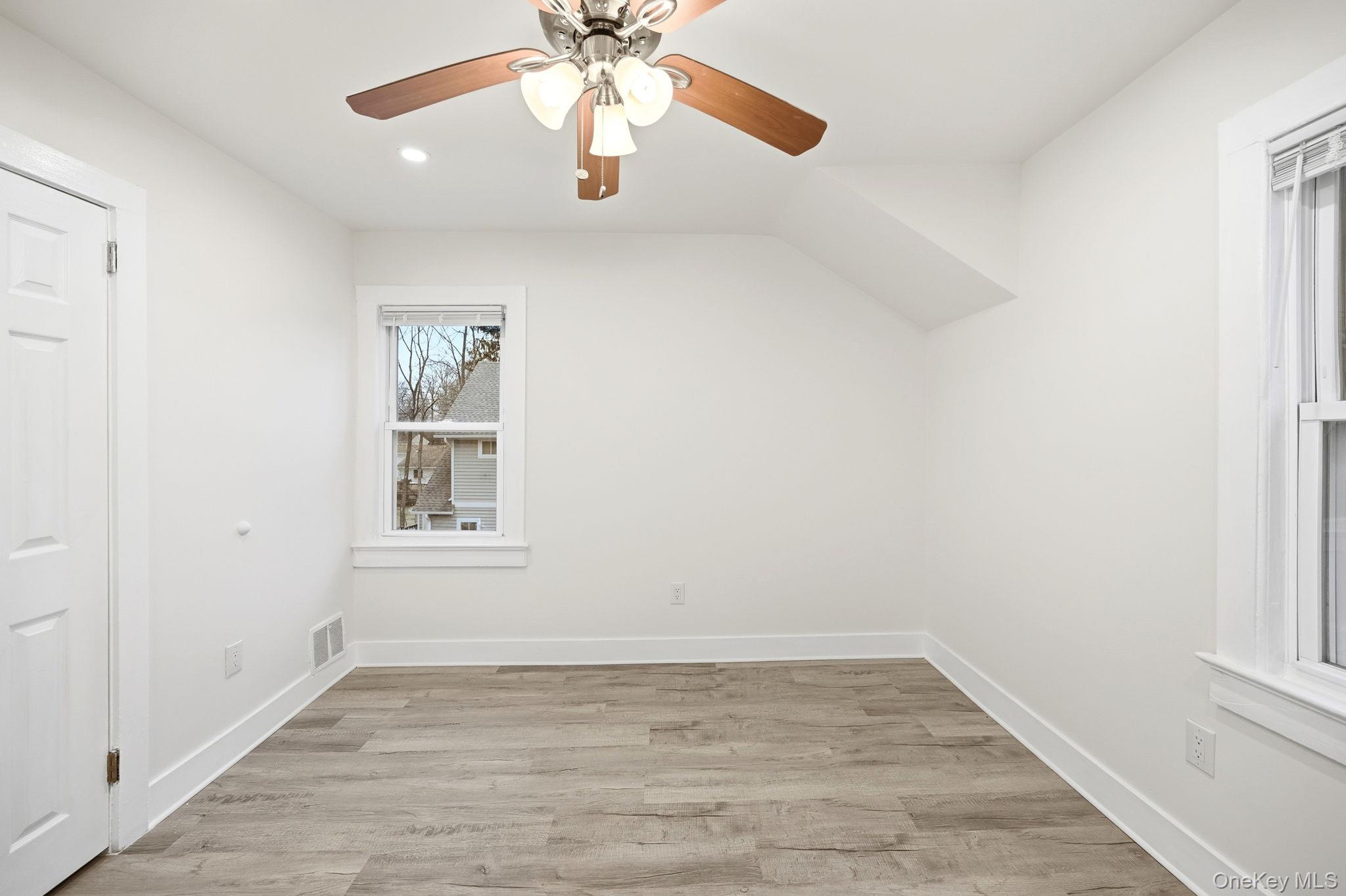359 Orangeburg Road, Unit 2 Pearl River, NY 10965 - Photo 32 of 39 an empty room with wooden floor chandelier fan and windows