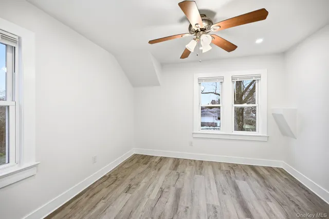 an empty room with a window and a ceiling fan
