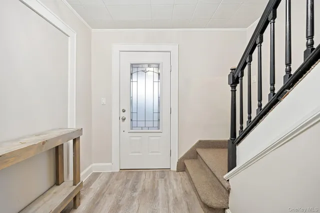 a view of an entryway with wooden floor and stairs