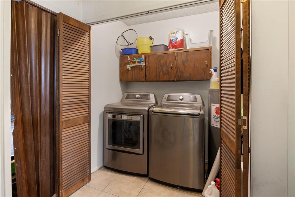 4210 Waples Road Granbury, TX 76049 - Photo 27 of 37 Dedicated utility space featuring a built-in wood-finish cabinet, neutral wall paint, and tile flooring