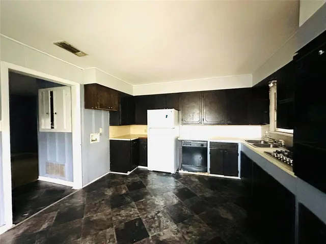 a kitchen with stainless steel appliances a refrigerator and a stove top oven