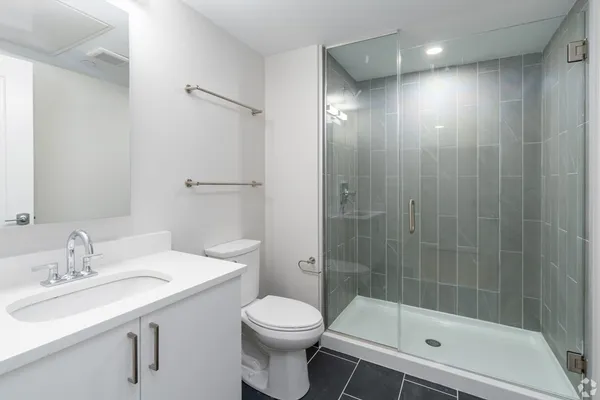 a bathroom with a sink a toilet and shower