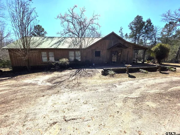 a wooden house covered with snow in front of it