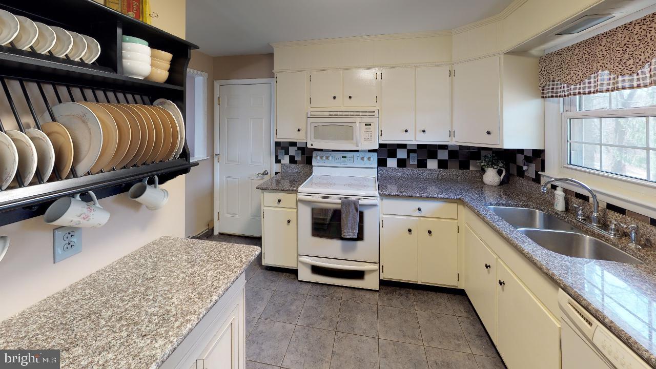 793 Mountain View Road Reading, PA 19607 - Photo 5 of 21 a kitchen with granite countertop a sink a stove and cabinets