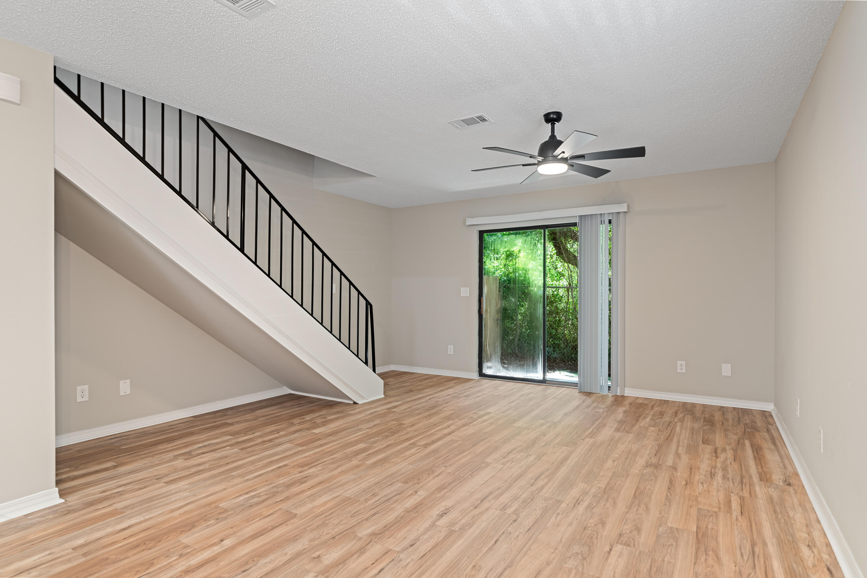 1681 Highway 98, Unit 3 Mary Esther, FL 32569 - Photo 7 of 21 a view of an empty room with wooden floor and a ceiling fan