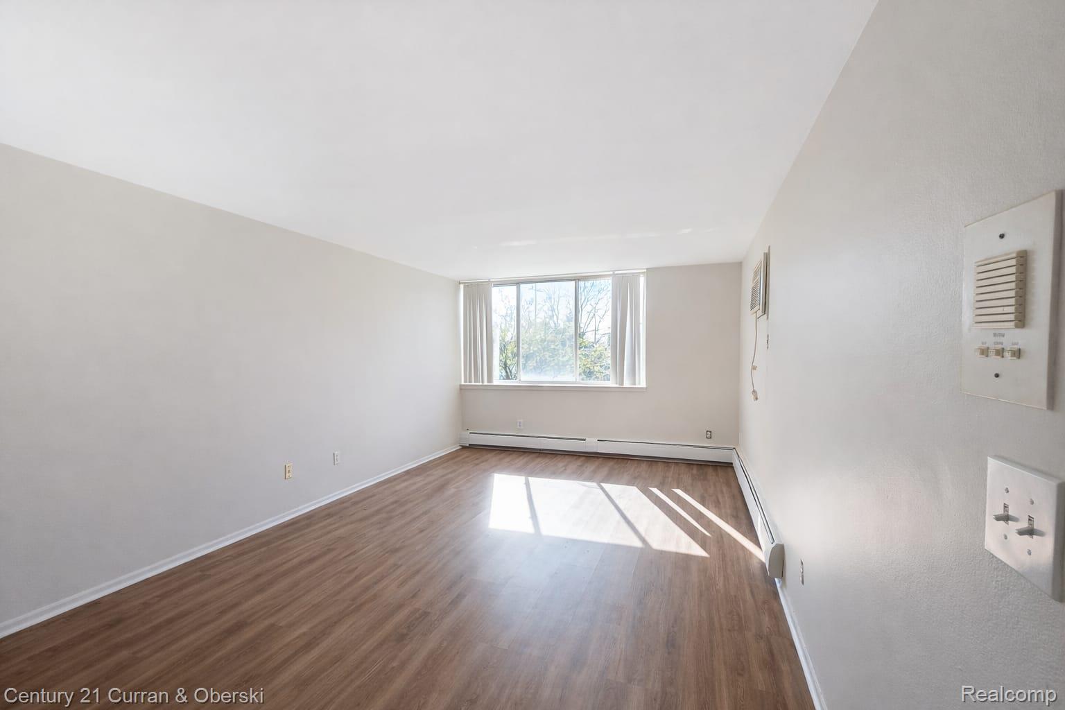 6015 Southfield Road, Unit 6 Detroit, MI 48228 - Photo 10 of 10 Unfurnished room featuring dark wood finished floors and baseboard heating