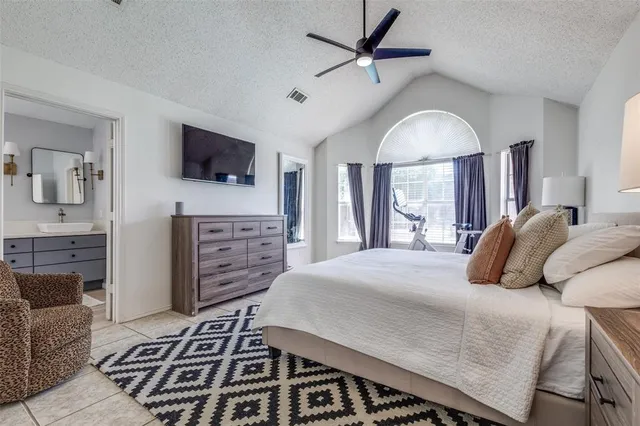 a bedroom with a bed a flat screen tv and dresser