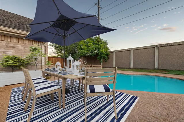 a view of a patio with table and chairs under an umbrella