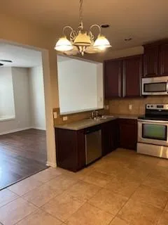 a kitchen with stainless steel appliances granite countertop a stove cabinets and wooden floor
