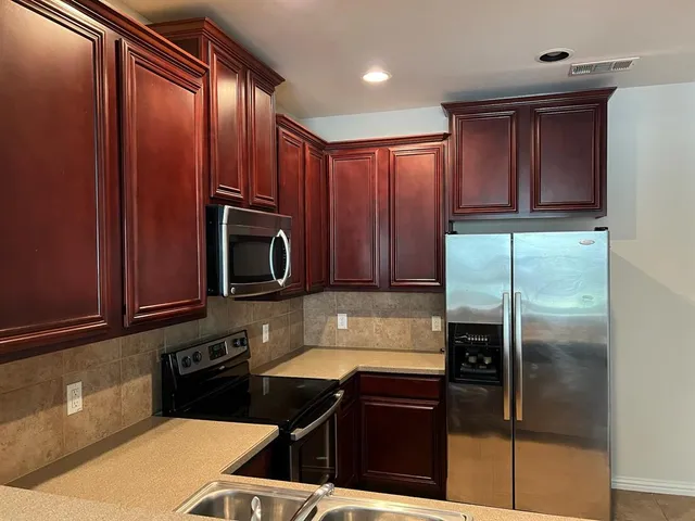 a kitchen with a sink a microwave and cabinets