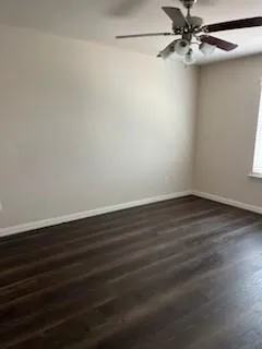 a view of a room with wooden floor and a ceiling fan