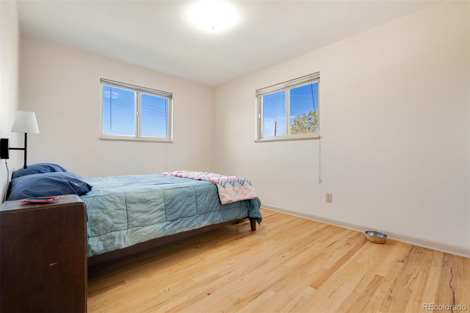 11760 West 32nd Avenue Wheat Ridge, CO 80215 - Photo 21 of 28 a bedroom with a bed and wooden floor