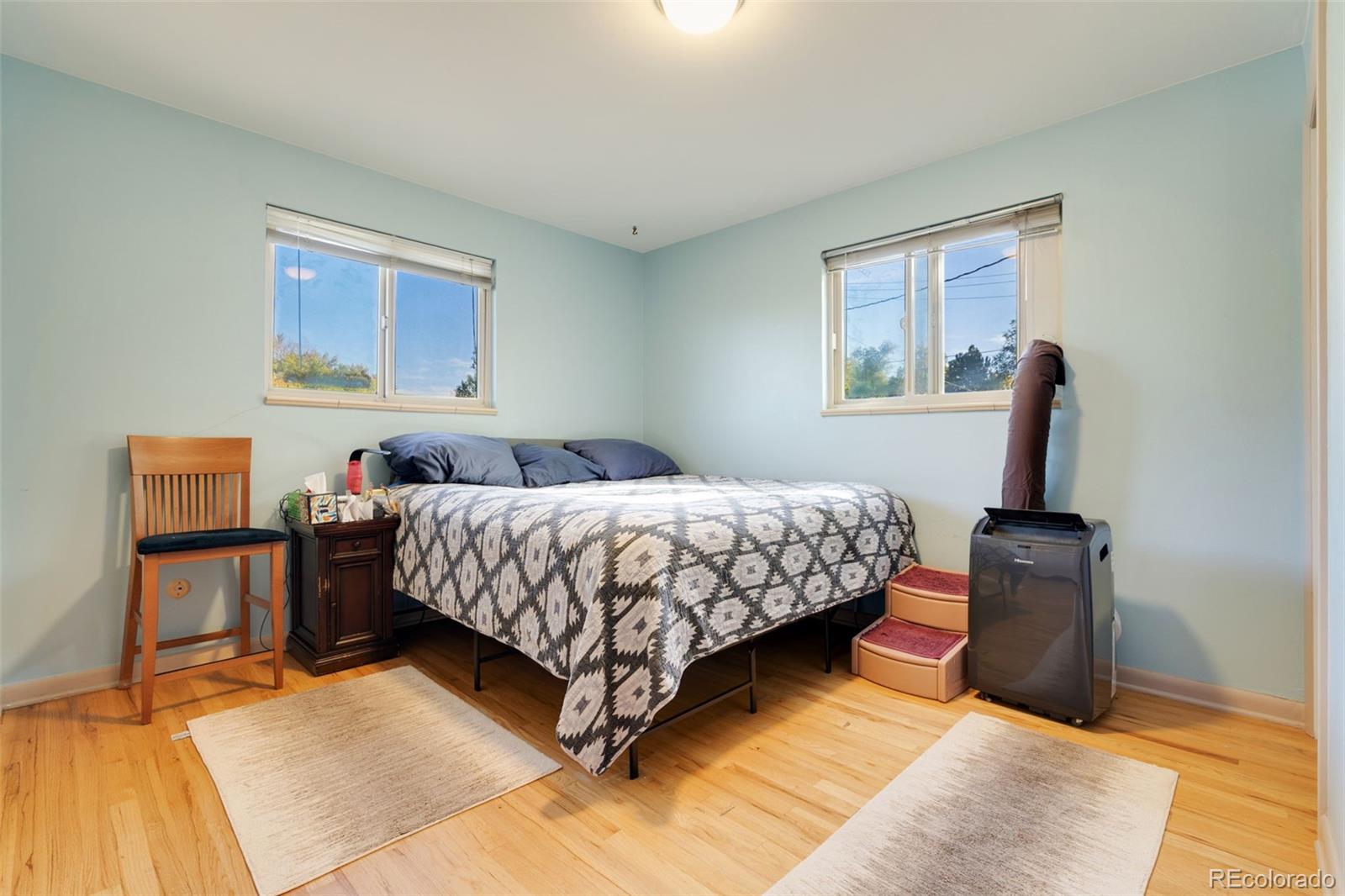 11760 West 32nd Avenue Wheat Ridge, CO 80215 - Photo 9 of 28 a bedroom with a bed wooden floor and lamp