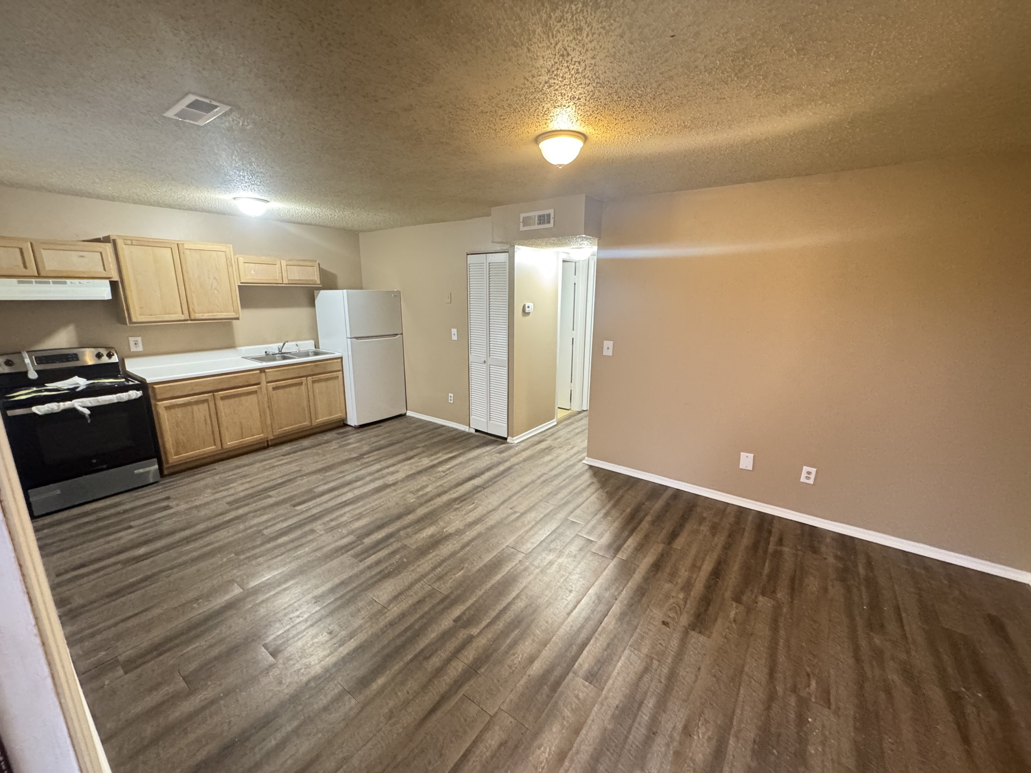 1523 Yager Road, Unit E2 McMinnville, TN 37110 - Photo 1 of 4 a large kitchen with a wooden floor and stainless steel appliances