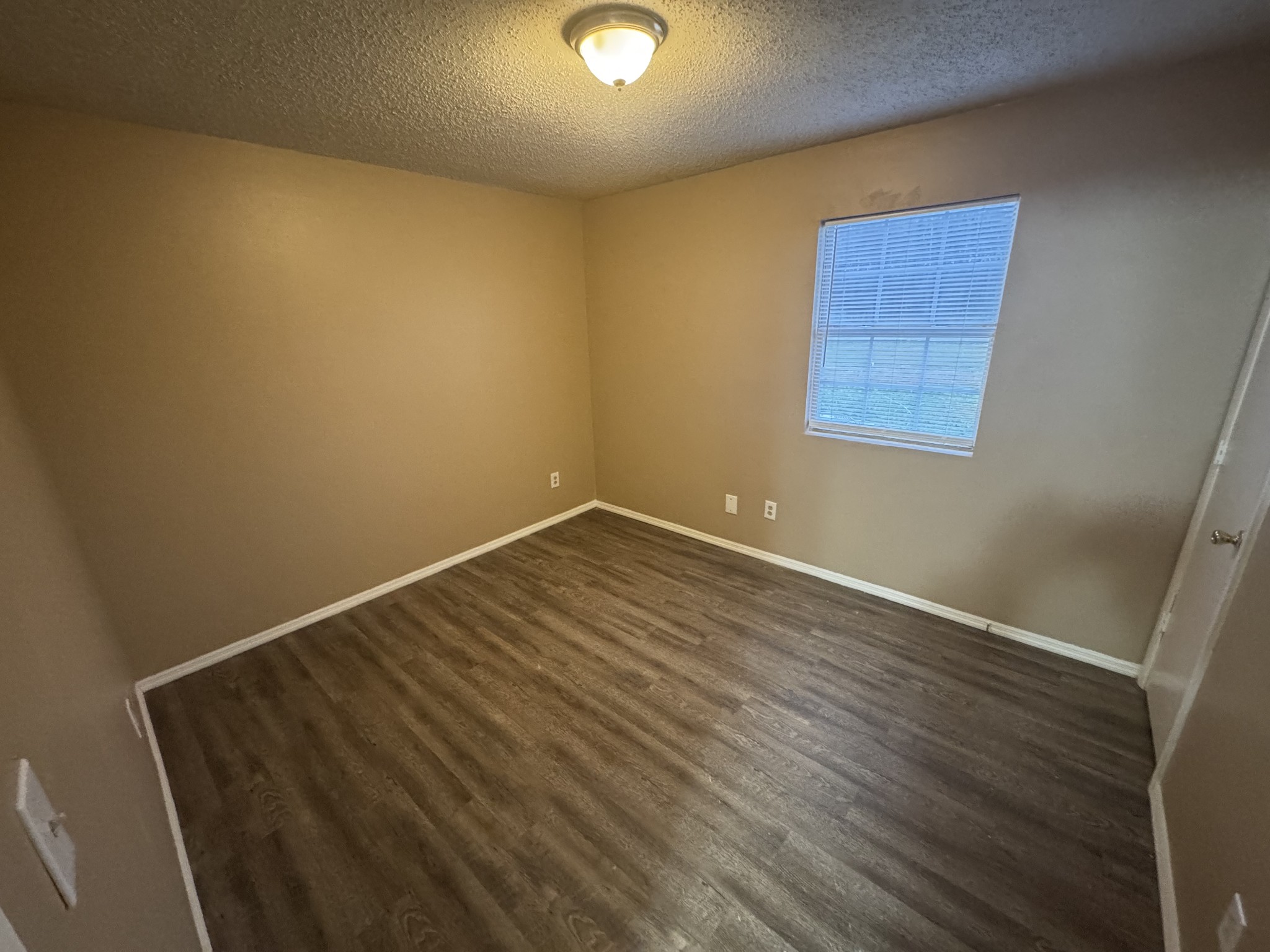 1523 Yager Road, Unit E2 McMinnville, TN 37110 - Photo 3 of 4 an empty room with wooden floor and windows