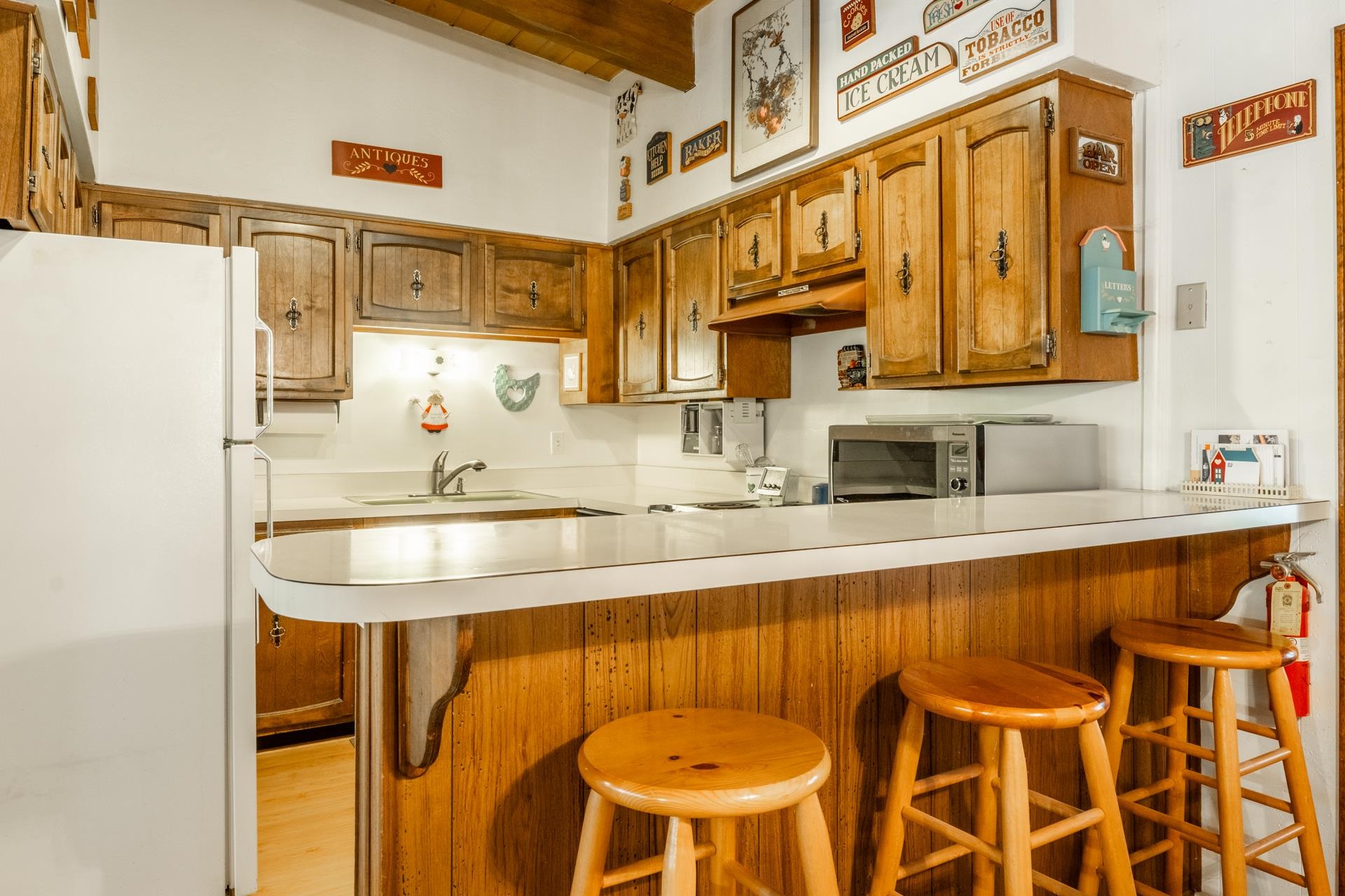 50 Hidden Valley Road, Unit 17 Mammoth Lakes, CA 93546 - Photo 13 of 40 Kitchen featuring wood-finish cabinetry, white countertops, and a breakfast bar