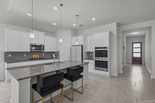 a kitchen with stainless steel appliances granite countertop a stove refrigerator and cabinets