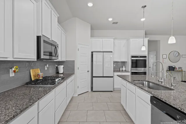 a kitchen with stainless steel appliances granite countertop a sink stove and microwave