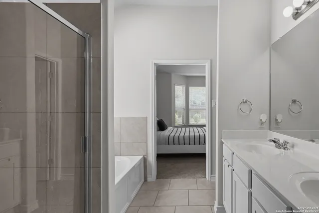 a spacious bathroom with a tub sink and mirror