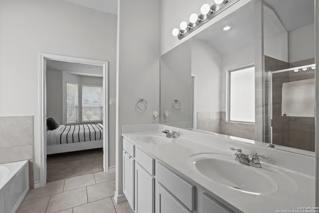 a en suite bathroom with a double vanity sink and a mirror