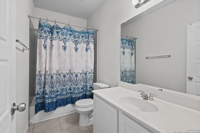 a bathroom with a sink a toilet and shower curtain