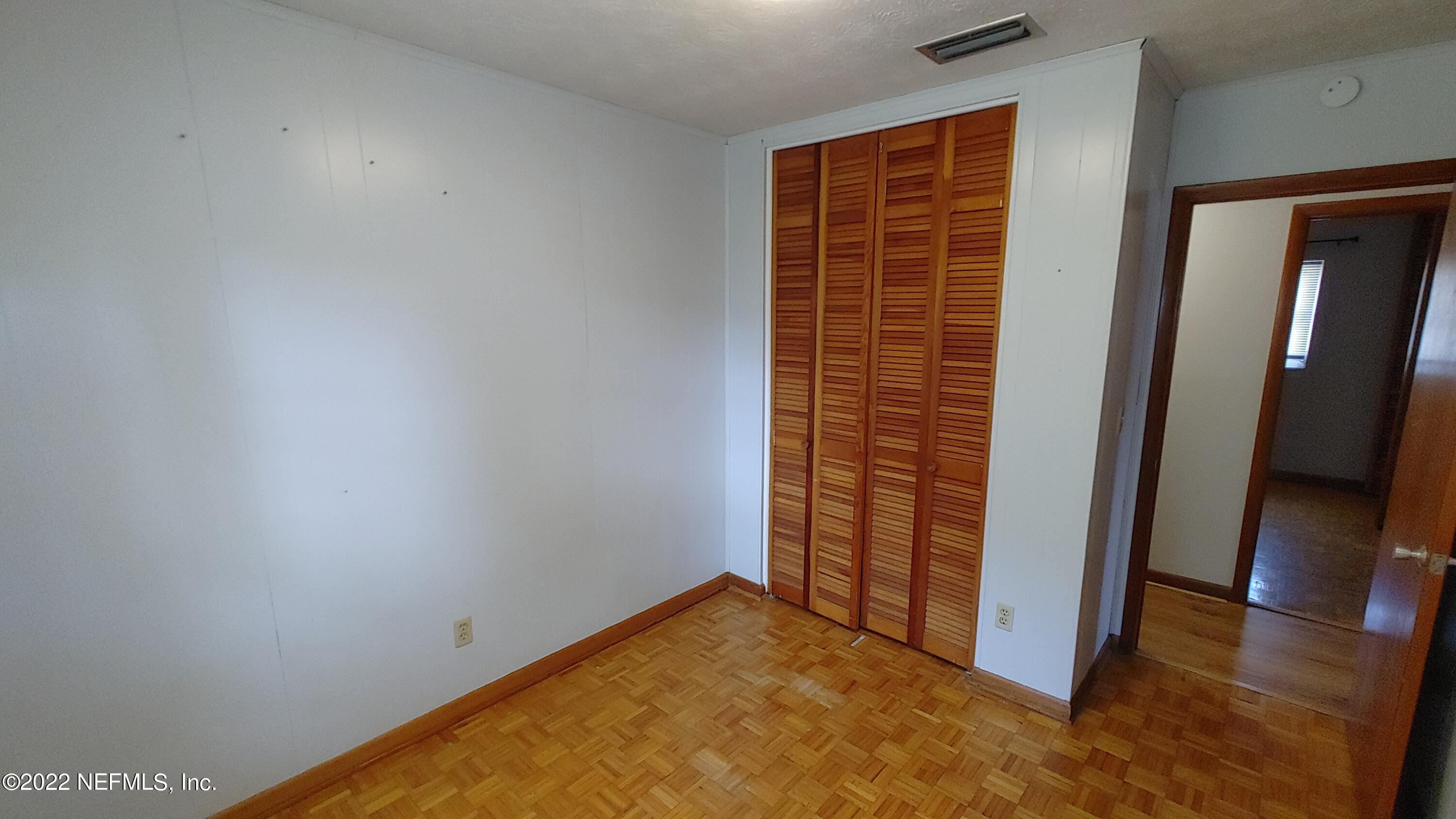 8280 Barracuda Road Jacksonville, FL 32244 - Photo 10 of 13 an empty room with wooden floor and windows